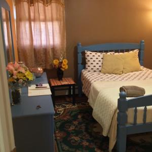 LaureltonBeautiful Room near JFK and close to LaGuardia Airports的一间卧室配有蓝色的床和鲜花桌