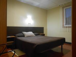塔拉戈纳翼可乐杰旅馆的卧室配有一张床,墙上有灯