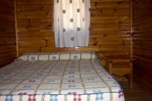 莫拉塔利亚拉普埃尔塔营地的一间位于小屋内的卧室,配有一张床和一个窗户