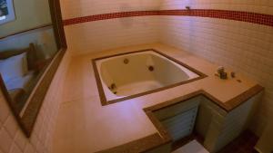 瓜皮米林POUSADA DAS ORQUIDEAS20的带浴缸的浴室,铺有瓷砖地板