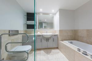 奥克兰Avani Metropolis Auckland Residences的浴室配有卫生间、盥洗盆和浴缸。