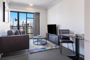 奥克兰Avani Metropolis Auckland Residences的客厅配有沙发和桌子