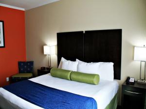 圣安东尼奥市景水中央套房酒店的酒店客房,配有一张带绿色枕头的床