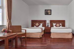 金边金边卡塔酒店 的酒店客房设有两张床和一张桌子。