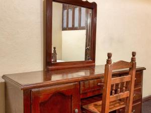 瓦哈卡市Hotel Esperanza, Oaxaca Centro的木制梳妆台,配有镜子和木椅