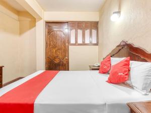瓦哈卡市Hotel Esperanza, Oaxaca Centro的一间卧室配有红色和白色枕头的床