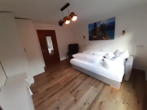 弗林肯贝格图克瑟泰尔公寓酒店的卧室配有白色的床和木地板