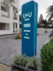 马公U+U加倍游民宿的建筑前的蓝色标志