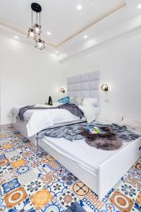 麦克坦FRESIA by J&J ( Near Airport. 50 Mbps Wifi .Netflix )的一间卧室设有两张床,铺有色彩缤纷的地板。