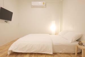 曼谷Petra Boutique Donmuang的卧室配有白色的床和电视