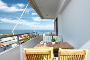 干尼亚Stefan's Penthouse的一个带木桌和椅子的海景阳台