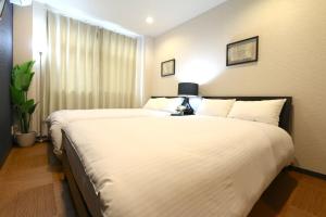 大阪EK1 Elizabeth Garden Kuromon的酒店客房设有两张床和窗户。