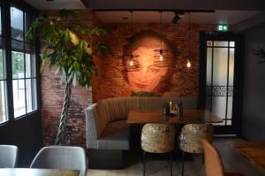 丽兹天使餐厅酒店的一间用砖墙装饰的用餐室,墙上涂有面孔