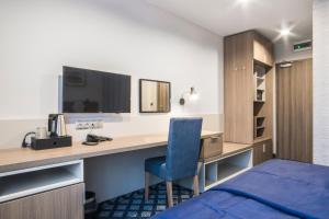 格但斯克Hotel Urbi的酒店客房配有一张桌子、一张床和一张蓝色椅子