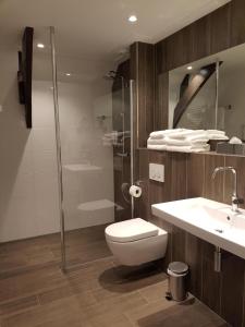 滨海卡特韦克赫伯格·维尔格勒根酒店的浴室配有卫生间、盥洗盆和淋浴。