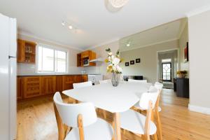 AberdareRenovated Little Cottage Aberdare Hunter Valley的厨房以及带白色桌椅的用餐室。