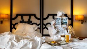 塔维拉塔维拉修道院酒店的女人坐在床上看杂志