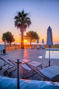 莫里亚尼海滩Casa e Natura的一个带桌子和遮阳伞的游泳池以及棕榈树