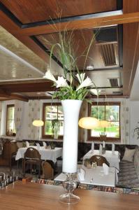 Breitenbach am Inn肖伯尔宾馆的餐厅的一张桌子上花的白色大花瓶