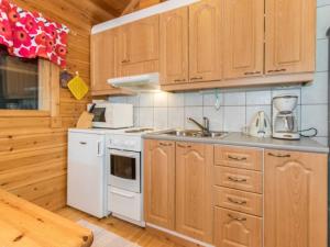 伊萨尔米Holiday Home Käenpesä by Interhome的厨房配有木制橱柜和白色炉灶烤箱。