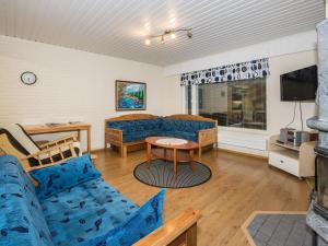伊萨尔米Holiday Home Oriaho by Interhome的客厅配有蓝色的沙发和电视