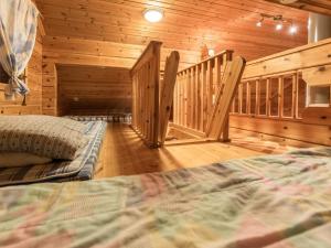 伊萨尔米Holiday Home Käenpesä by Interhome的小木屋内一间卧室配有床和楼梯