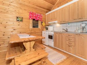伊萨尔米Holiday Home Käenpesä by Interhome的厨房配有木制橱柜和木桌。