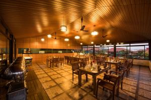 马迪凯里Woodstock Resorts的餐厅设有木桌、椅子和窗户。