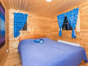 伊萨尔米Holiday Home Käenpesä by Interhome的小木屋内一间卧室,配有一张蓝色的床
