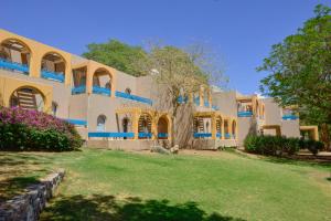 埃拉特Club In Eilat Resort - Executive Deluxe Villa With Jacuzzi, Terrace & Parking的前面有一棵树的大建筑