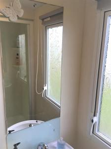 斯凯格内斯Revamped & Upgraded 6 Berth Static Caravan on Southview Skegness的浴室设有镜子、水槽和窗户
