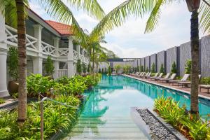 新加坡The Barracks Hotel Sentosa by Far East Hospitality的棕榈树度假村庭院内的游泳池