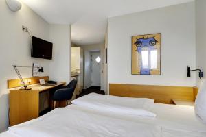 斯文堡伽尼酒店的一间酒店客房,配有一张白色的床和一张书桌