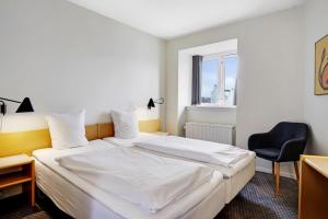 斯文堡伽尼酒店的一间卧室配有一张床、一张桌子和一把椅子