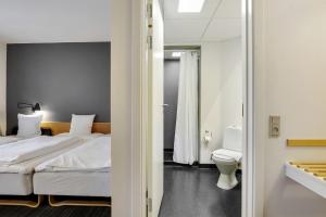 斯文堡伽尼酒店的酒店客房设有一张床和一个卫生间。