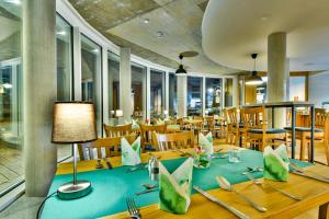 赛巴特班森Hotel am Fischerstrand的一间配备有蓝色桌子和椅子的用餐室