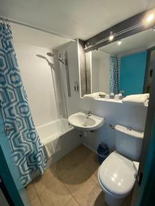 加来海滨酒店的浴室配有白色卫生间和盥洗盆。