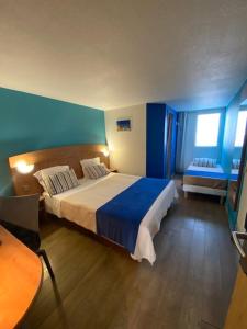 加来海滨酒店的一间卧室配有一张带蓝色墙壁的大床