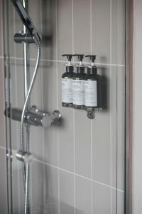 DonsöHotel Isbolaget的两瓶气味器坐在淋浴的墙上