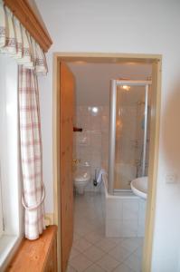 加尔米施-帕滕基兴玛丽亚宾馆的浴室配有卫生间、浴缸和水槽。