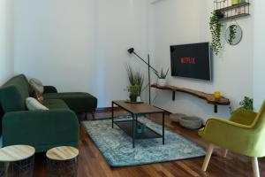 雅典A10 SecretHouse的客厅配有两把绿色椅子和电视