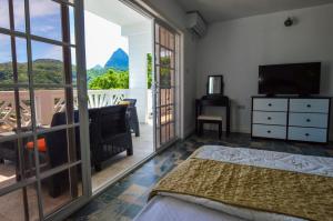 苏弗里耶尔Sugarmon Villas的一间卧室配有一张床、一台电视和一个阳台