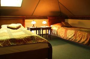 兰卡特帕拉基旅馆的一间卧室配有两张床和一张带两盏灯的桌子。