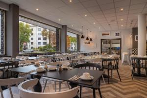 柏林Yggotel Ravn的用餐室设有桌椅和窗户。