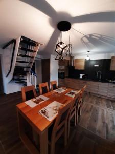 La Plagne TarentaiseLa Maison Trésallet的一间带木桌和椅子的用餐室