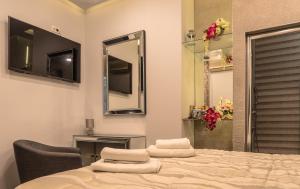 斯普利特多米纳别墅酒店的一间卧室配有一张床、镜子和椅子
