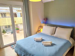 雅典Renovated apartment close to Exarchia square的一间卧室配有蓝色的床和2条毛巾