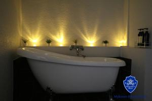 横须贺市Mykonos Resort Miura / Vacation STAY 62208的浴室设有白色浴缸,墙上装有灯