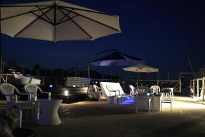 横须贺市Mykonos Resort Miura / Vacation STAY 62208的一群椅子和遮阳伞在晚上在庭院里