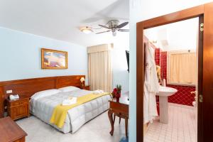 萨萨里马里尼酒店的一间卧室配有一张床,浴室设有水槽